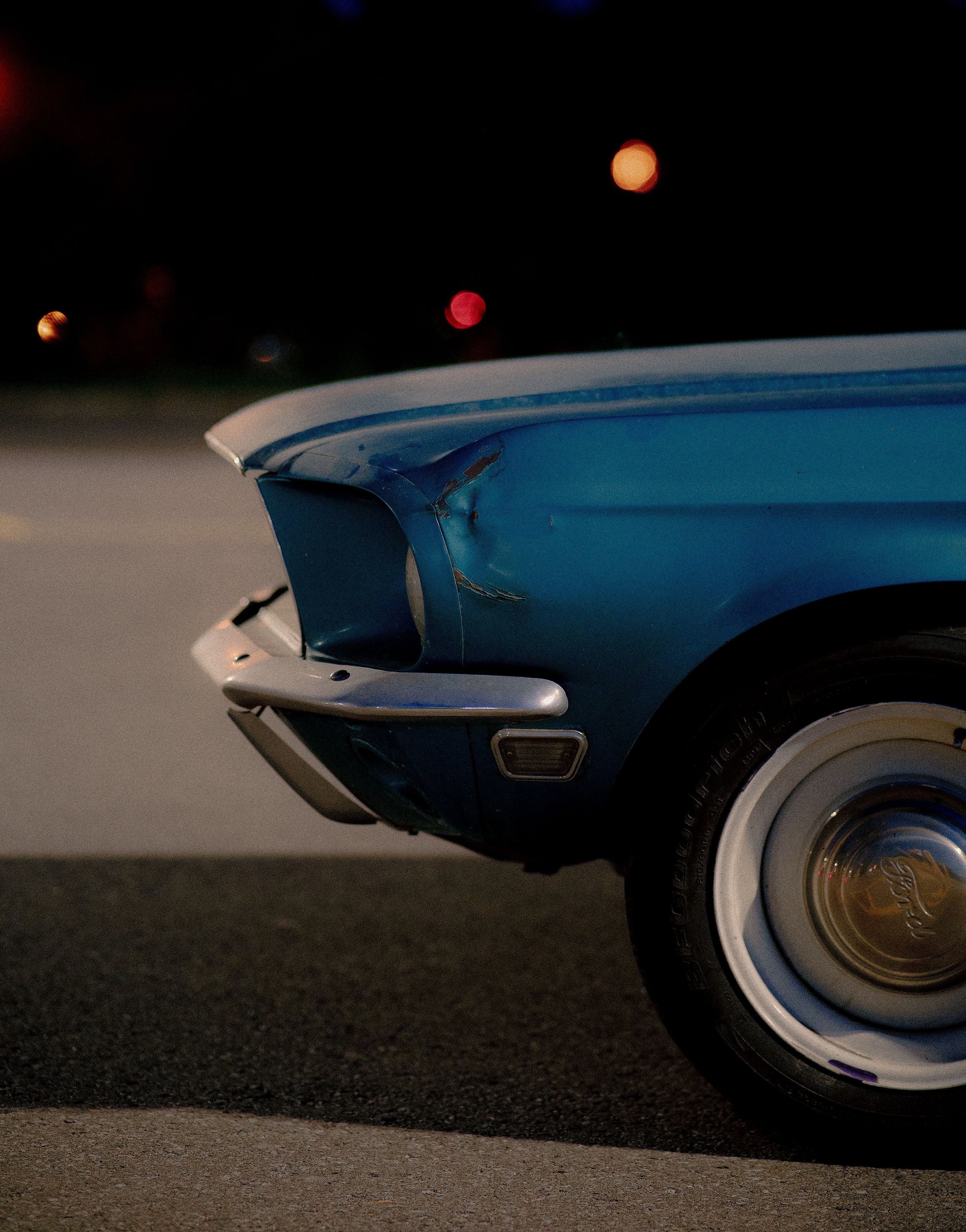 Stock photo of a blue car with a dented front fender; not the fictional vehicle below.